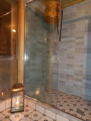 a glass shower with a candle on a counter at Apartmány Kamenka in Mičovice
