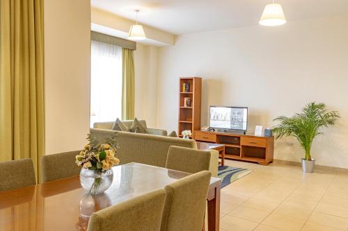 a living room with a table and a couch at Roda Amwaj Suites Jumeirah Beach Residence in Dubai