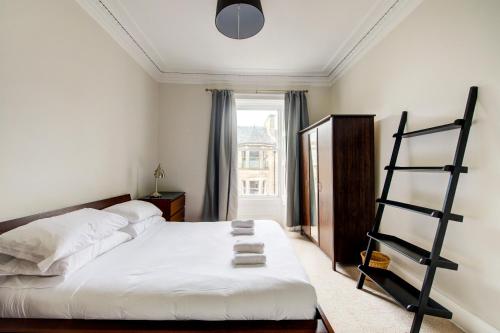 een slaapkamer met een bed met een ladder en een raam bij GuestReady - Amazing apt near The Meadows in Edinburgh