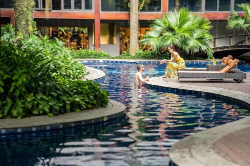 a woman and a child playing in a swimming pool at Fraser Suites Hanoi in Hanoi