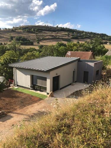 a small white house in the middle of a field at Gite du Travers in Sébrazac