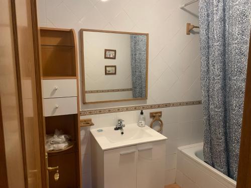 een badkamer met een wastafel, een spiegel en een bad bij Casa del Plantel in La Granja de San Ildefonso