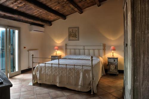 um quarto com uma cama e 2 candeeiros nas mesas em Palazzo Bella em Campobello di Licata