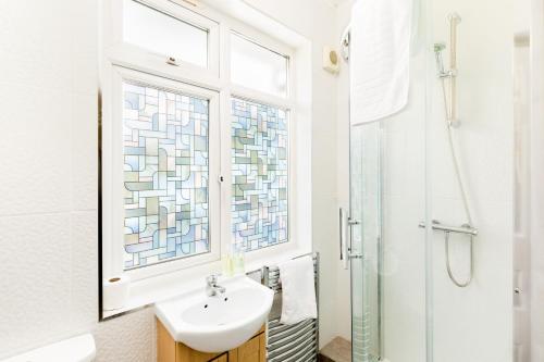 a bathroom with a sink and a window at Beautiful 6 bedroom house for 17 guests next to Edgbaston Stadium in Birmingham