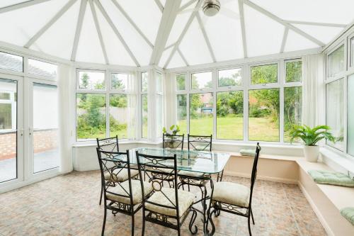 a dining room with a glass table and chairs at Beautiful 6 bedroom house for 17 guests next to Edgbaston Stadium in Birmingham