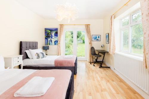 a bedroom with two beds and a desk at Beautiful 6 bedroom house for 15 guests next to Edgbaston Stadium in Birmingham