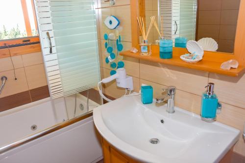 e bagno con lavandino, specchio e vasca. di Sea View Two Bedroom Villa Giorgios a Gavalochori