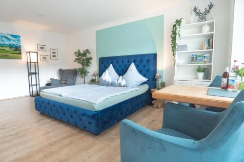 1 dormitorio con 1 cama azul y 2 sillas azules en Ferienwohnung BergPfote en Scheidegg
