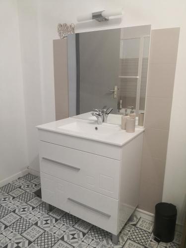 une salle de bain blanche avec un lavabo et un miroir dans l'établissement Chez Alex et Sophie, à Louzac - Saint-André