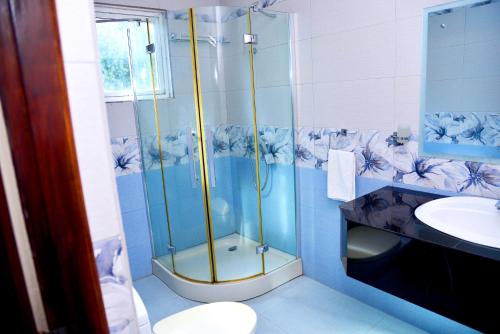 a bathroom with a shower and a sink at Little Villa Hotel in Wadduwa