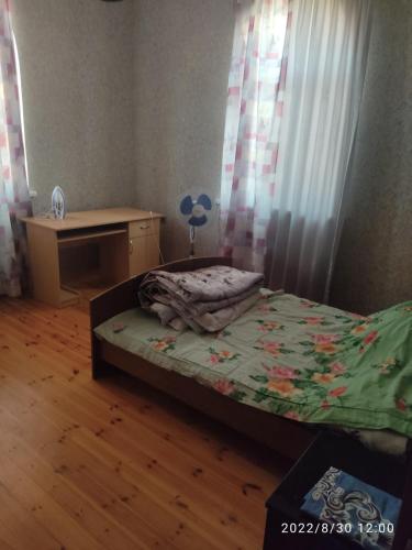 ein kleines Schlafzimmer mit einem Bett und einem Schreibtisch in der Unterkunft Cozy home for leisure in Baku