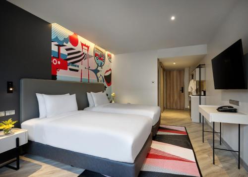 a hotel room with a white bed and a kitchen at Oakwood Studios Sukhumvit Bangkok in Bangkok