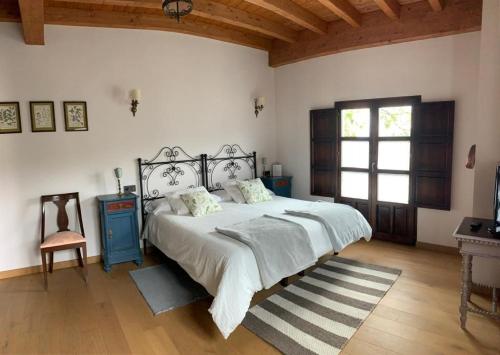 a bedroom with a bed and a table and a window at La Ribera de Pría in Villanueva de Pría