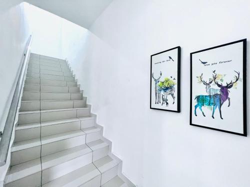 eine Treppe mit drei Bildern von Tieren an der Wand in der Unterkunft SingBeach holiday house in Mersing