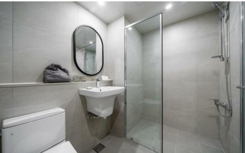 a bathroom with a toilet and a sink and a shower at Geoje Mongdol Beach H Avenue Hotel in Geoje 