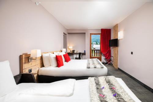 ヴァルフレジュスにあるSOWELL Family Valfrejusのベッド2台とテレビが備わるホテルルームです。