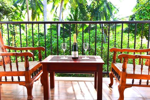 a table with a bottle of wine and two chairs at Little Villa Hotel in Wadduwa