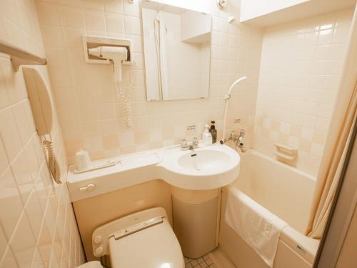 a bathroom with a sink and a toilet and a tub at Hotel Castle Inn Suzuka in Suzuka