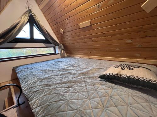łóżko w małym domku z oknem w obiekcie Tatrydom Apartament Loft z kominkiem w Zakopanem