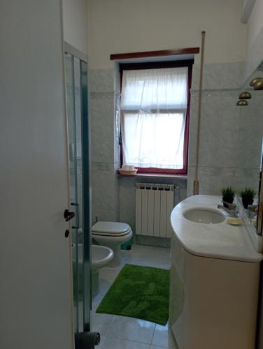baño con lavabo y aseo y ventana en B&B "Feelgood", en Roma