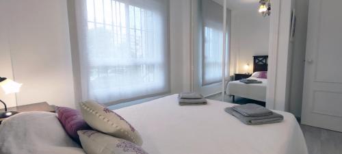 una camera da letto bianca con un letto e una finestra di Laguna Beach - Coral Side a Torrox Costa
