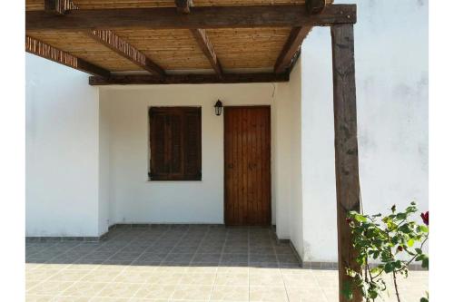 ein Gebäude mit einer Holztür und einer Veranda in der Unterkunft Μaria's house 1 in Edipsos