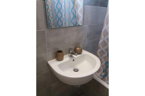 um lavatório branco na casa de banho com um espelho em Μaria's house 1 em Edipsos