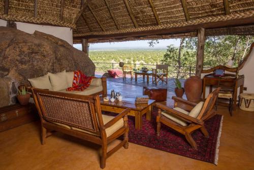 a living room with a couch and chairs and a table at Elewana Elsa's Kopje in Meru