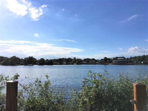 a view of a lake with a house in the distance at Tattershall Lakeside Lodge Indulgent wheelchair accessible 8 berth with Hot Tub in Tattershall
