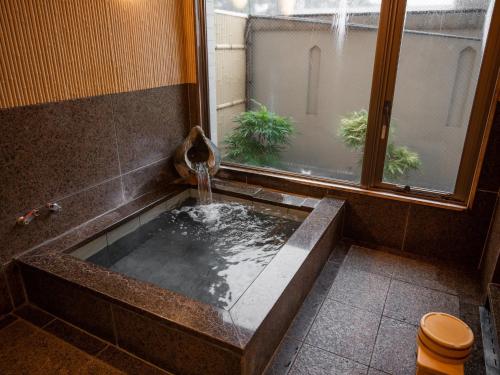 a bathroom with a tub with a water fountain at Hotel Castle Inn Suzuka Chuo in Suzuka