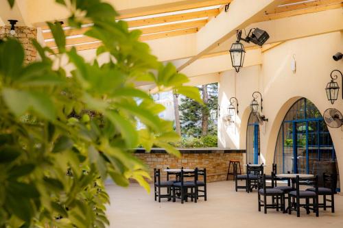 Navarria Blue Hotel في ليماسول: فناء به طاولات وكراسي في مبنى