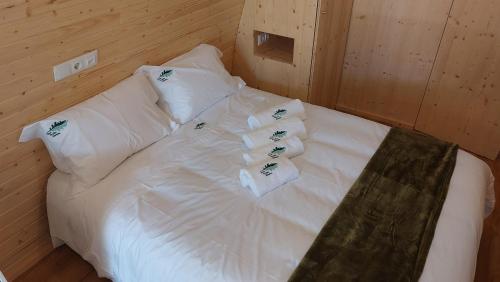 a bed in a room with white sheets and pillows at Green Paradise Glamping in Covas