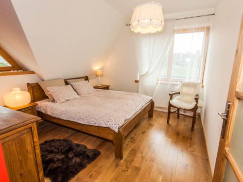 una camera con un letto e una sedia e una finestra di Apartament w Osadzie Podhalańskiej a Gliczarów