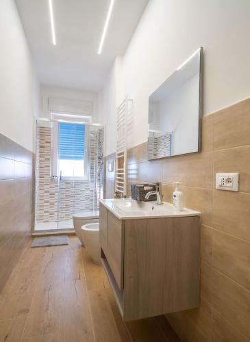 a bathroom with a sink and a toilet and a mirror at Fix You Apartment Fco in Fiumicino