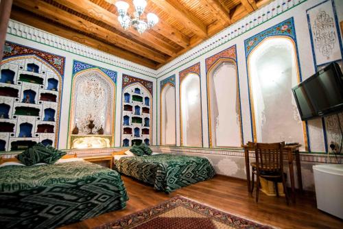 a hotel room with a bed and a television at Boutique Hotel Minzifa in Bukhara