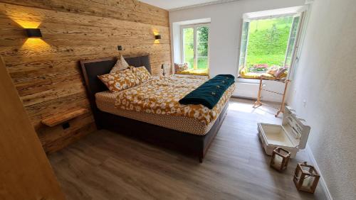 a bedroom with a bed with a wooden wall at Allegra Appenzell in Trogen