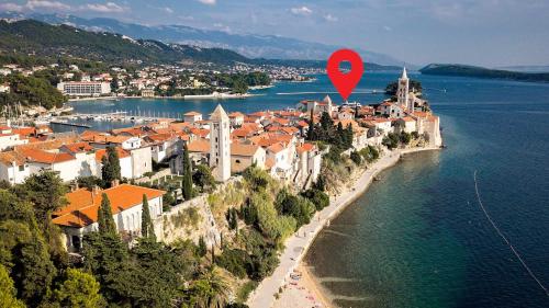a town on a hill with a red marker at Rector's Villa - Charming Retreat in Old Town with Jacuzzi in Private Courtyard in Rab