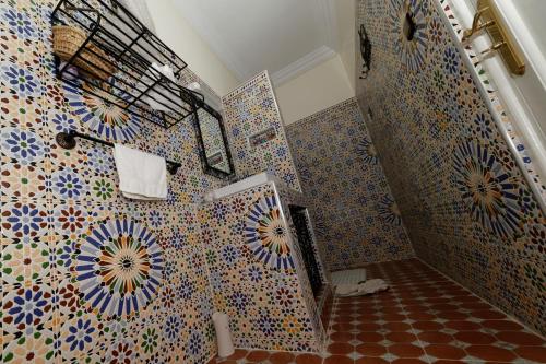 a bathroom with colorful tiles on the wall at Riad Parfums de OUARZAZATE in Ouarzazate