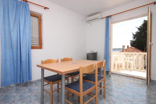a dining room with a table and chairs and a large window at Apartments by the sea Petrcane, Zadar - 6269 in Petrcane
