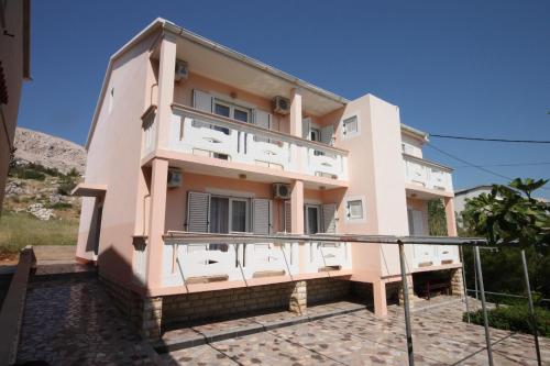 a building with a balcony in front of it at Rooms by the sea Metajna, Pag - 6378 in Metajna