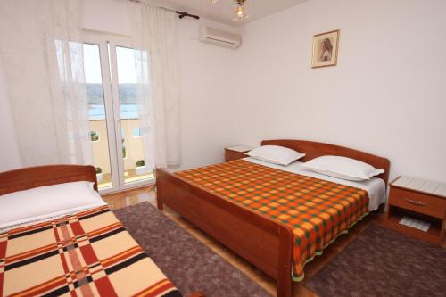 a bedroom with two beds and a window at Rooms by the sea Metajna, Pag - 6378 in Metajna