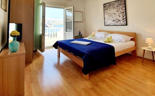 um quarto com uma cama com um cobertor azul e uma janela em Apartments with a parking space Metajna, Pag - 6423 em Metajna