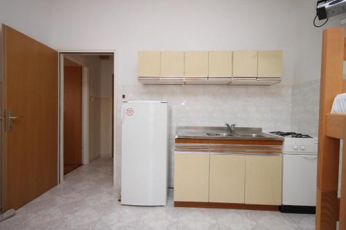 a kitchen with a white refrigerator and a sink at Apartments by the sea Jakisnica, Pag - 6285 in Lun