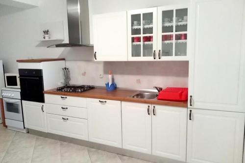 een keuken met witte kasten en een wastafel bij Rooms by the sea Kustici, Pag - 6288 in Kustići