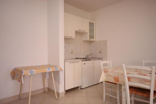 a small kitchen with a table and a sink at Apartments by the sea Jakisnica, Pag - 6424 in Lun