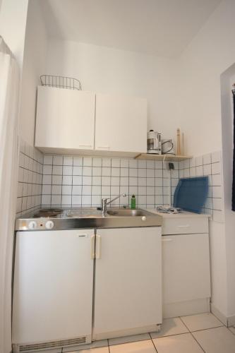 a kitchen with white cabinets and a sink at Apartments with a parking space Mandre, Pag - 6415 in Kolan