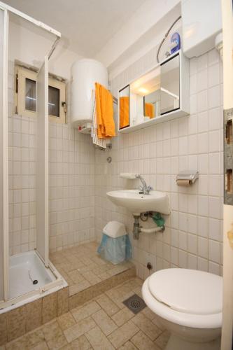 a bathroom with a toilet and a sink and a tub at Apartments and rooms with parking space Metajna, Pag - 6369 in Metajna