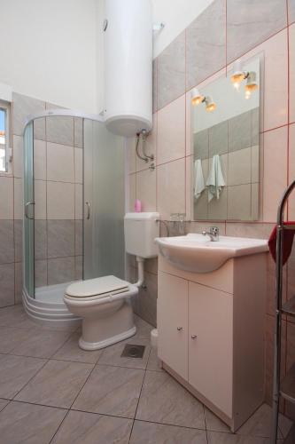 a bathroom with a toilet and a sink and a shower at Apartments and rooms with parking space Novalja, Pag - 6341 in Novalja