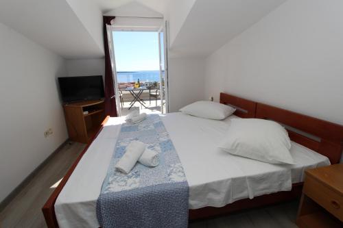 a bedroom with a bed with two towels on it at Apartments and rooms with parking space Mandre, Pag - 6309 in Kolan
