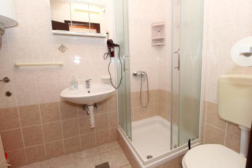 a bathroom with a shower and a sink and a toilet at Apartments and rooms with parking space Mandre, Pag - 6309 in Kolan